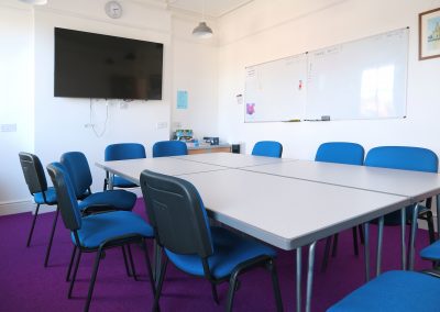 picture of large meeting room showing TV and white board